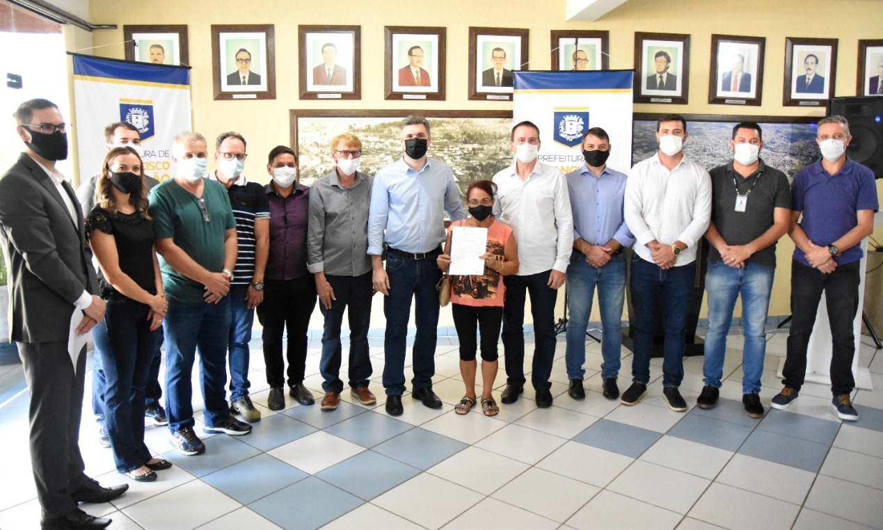 Foto: Helena Correia, uma das beneficiadas, recebendo a escritura da sua casa